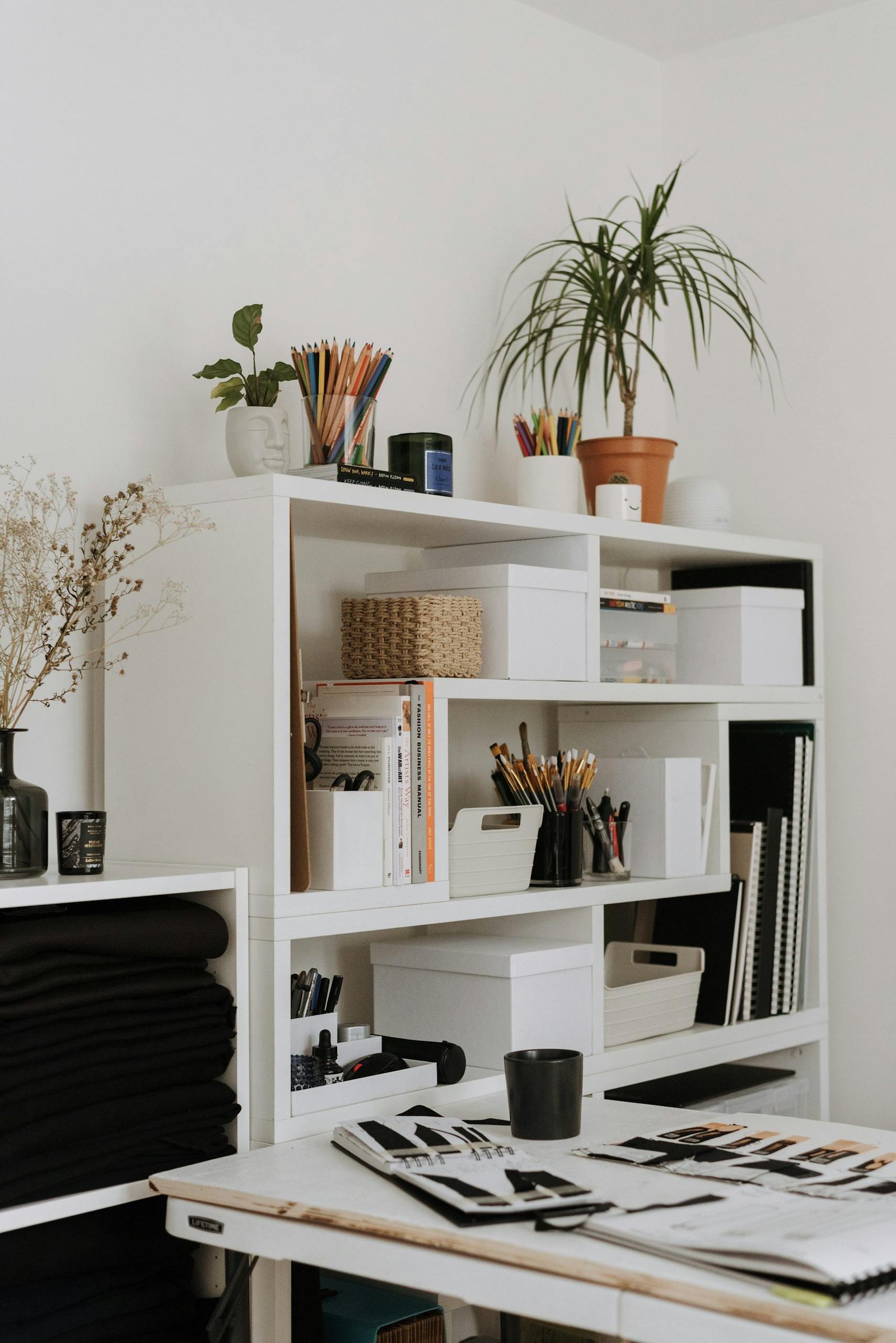 Supplies placed on table near shelves in light studio